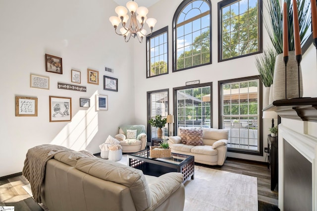 409 Summergreen Way, Greenville, SC 29607 - living room featuring a chandelier, a high ceiling, wood finished floors, and a fireplace with flush hearth