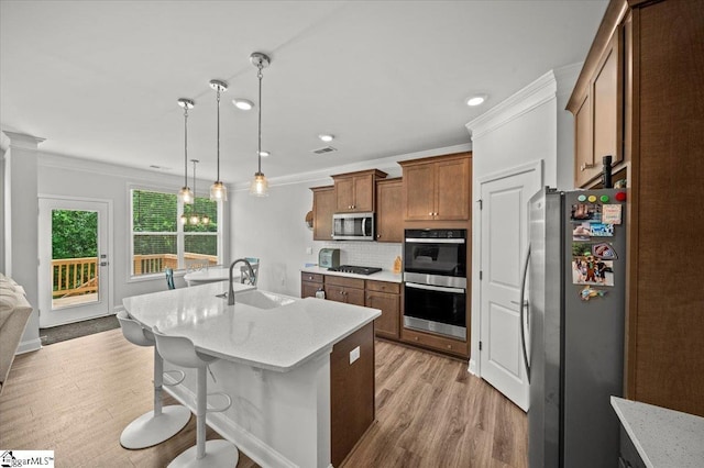 229 Layken Ln, Woodruff, SC 29388 - kitchen featuring stainless steel appliances, light wood-style flooring, decorative backsplash, light stone counters, and brown cabinets