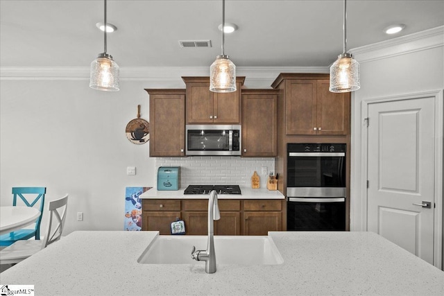 229 Layken Ln, Woodruff, SC 29388 - kitchen featuring stainless steel appliances, crown molding, decorative backsplash, hanging light fixtures, and light stone countertops