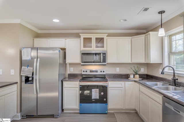 121 Stanmoore Dr, Anderson, SC 29621 - kitchen featuring appliances with stainless steel finishes, light wood-type flooring, ornamental molding, hanging light fixtures, and dark countertops