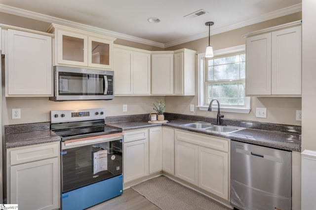 121 Stanmoore Dr, Anderson, SC 29621 - kitchen featuring appliances with stainless steel finishes, dark countertops, hanging light fixtures, crown molding, and light wood finished floors