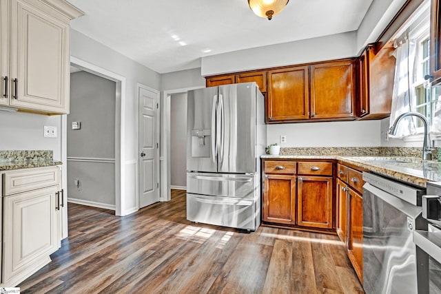 203 Camellia Ln, Simpsonville, SC 29681 - kitchen with stainless steel appliances, dark wood-style flooring, brown cabinetry, and light stone counters