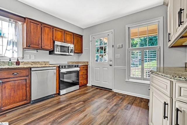 203 Camellia Ln, Simpsonville, SC 29681 - kitchen with stainless steel appliances, dark wood-style flooring, light stone counters, and brown cabinets