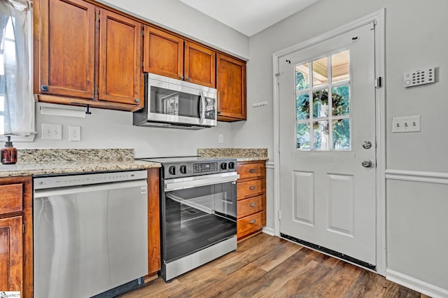 203 Camellia Ln, Simpsonville, SC 29681 - kitchen with appliances with stainless steel finishes, dark wood finished floors, brown cabinets, and light stone counters