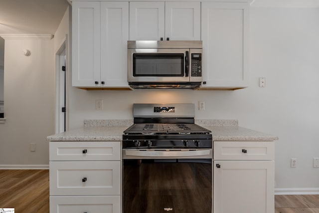 101 Clearbrook Ct, Greer, SC 29650 - kitchen featuring appliances with stainless steel finishes, light wood-style floors, white cabinetry, and light stone counters