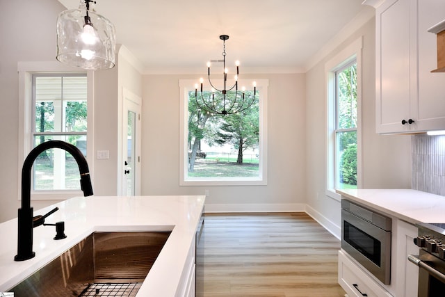 72 Seminole Dr, Simpsonville, SC 29680 - kitchen with appliances with stainless steel finishes, light wood-type flooring, a chandelier, pendant lighting, and crown molding