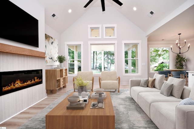 72 Seminole Dr, Simpsonville, SC 29680 - living area featuring high vaulted ceiling, a chandelier, a glass covered fireplace, light wood-style flooring, and ceiling fan