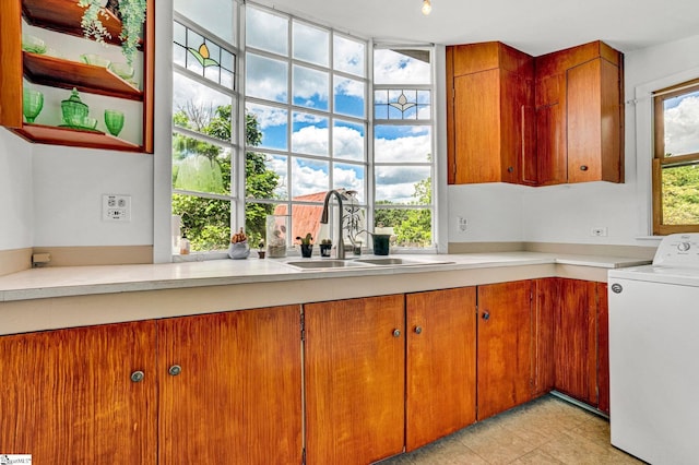 302 Douglas St, Laurens, SC 29360 - kitchen with washer / clothes dryer, light countertops, brown cabinetry, and light tile patterned flooring
