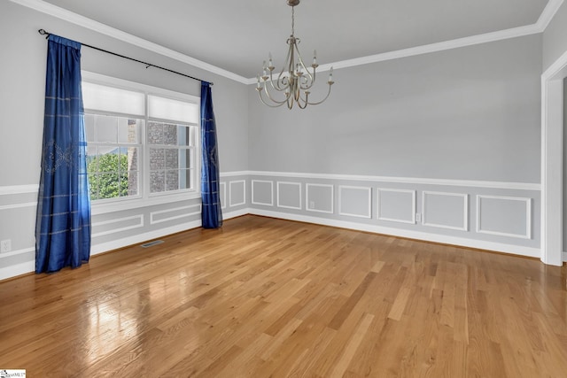 528 Carolee Way, Greer, SC 29651 - empty room featuring a chandelier, ornamental molding, wainscoting, light wood-style flooring, and a decorative wall