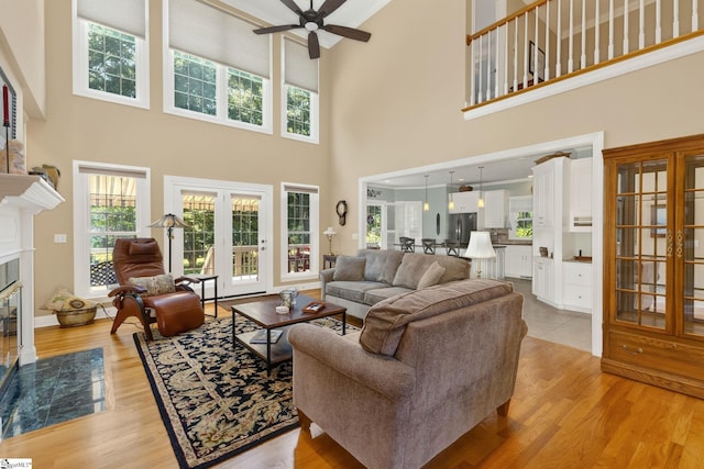 163 Tupelo Dr, Greer, SC 29651 - living room with a towering ceiling, ceiling fan, a fireplace with flush hearth, and light wood-style floors