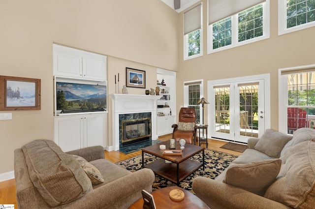 163 Tupelo Dr, Greer, SC 29651 - living area with wood finished floors, a fireplace, a towering ceiling, and built in features
