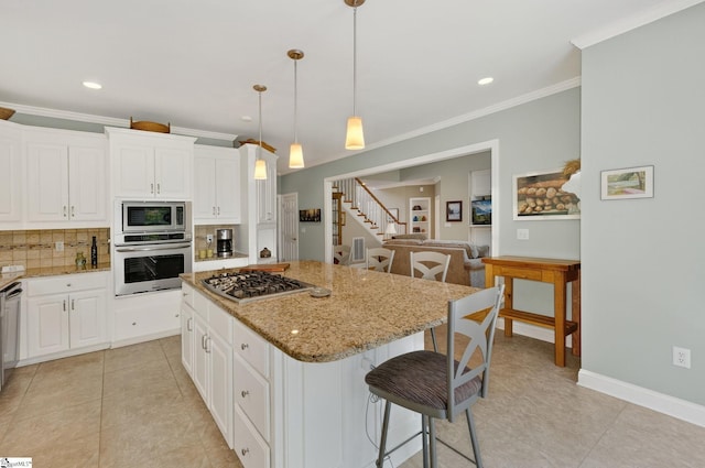 163 Tupelo Dr, Greer, SC 29651 - kitchen with appliances with stainless steel finishes, a center island, a kitchen breakfast bar, tasteful backsplash, and light tile patterned floors