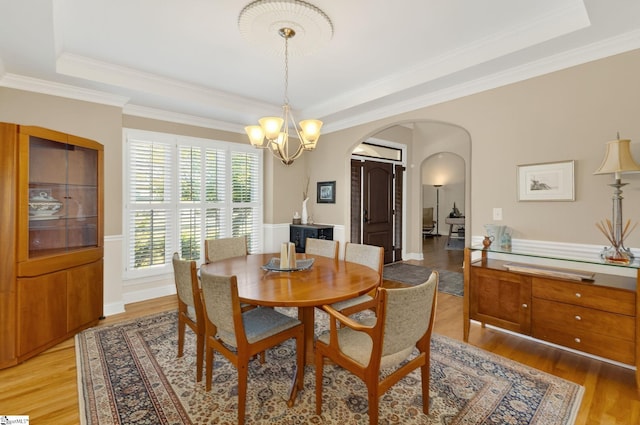 163 Tupelo Dr, Greer, SC 29651 - dining room with a raised ceiling, arched walkways, a chandelier, light wood-style floors, and ornamental molding