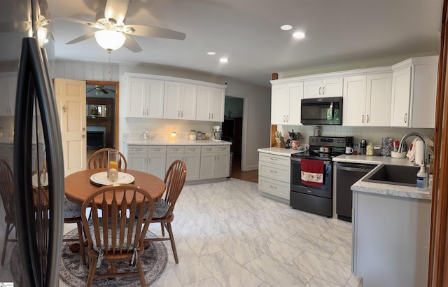 228 Styles Rd, Taylors, SC 29687 - kitchen with black appliances, ceiling fan, light countertops, white cabinetry, and decorative backsplash