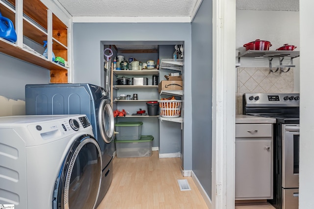 2 Line St, Taylors, SC 29687 - laundry area with light wood-style flooring, separate washer and dryer, and a textured ceiling