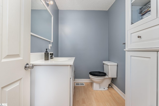 2 Line St, Taylors, SC 29687 - half bathroom with wood finished floors, vanity, and a textured ceiling