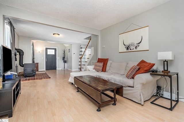 2 Line St, Taylors, SC 29687 - living area featuring a wood stove, light wood-style floors, stairway, and a textured ceiling