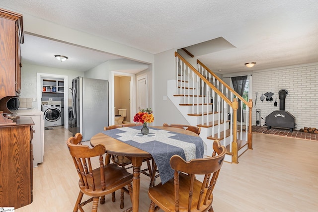 2 Line St, Taylors, SC 29687 - dining space with washer / dryer, a wood stove, light wood-style floors, stairway, and a textured ceiling