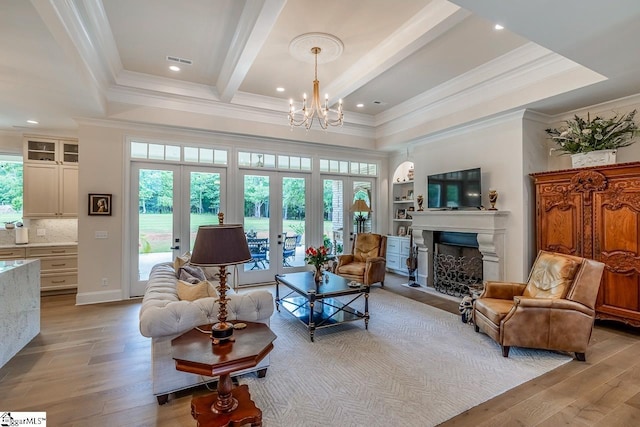 2765 Brockman Mcclimon Rd, Greer, SC 29651 - living area with ornamental molding, a chandelier, light wood-style floors, a fireplace with flush hearth, and french doors