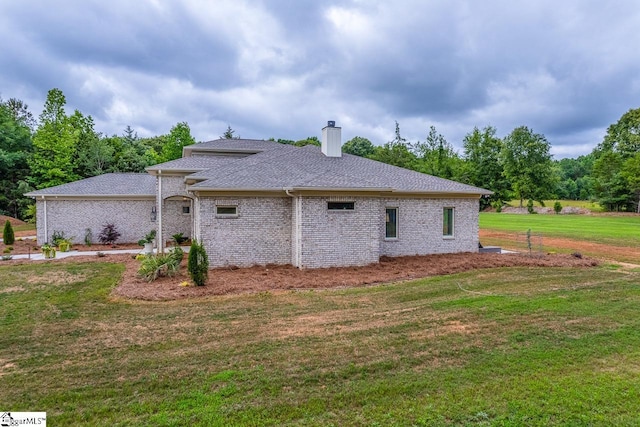 2765 Brockman Mcclimon Rd, Greer, SC 29651 - rear view of property featuring a lawn, a chimney, brick siding, and a shingled roof