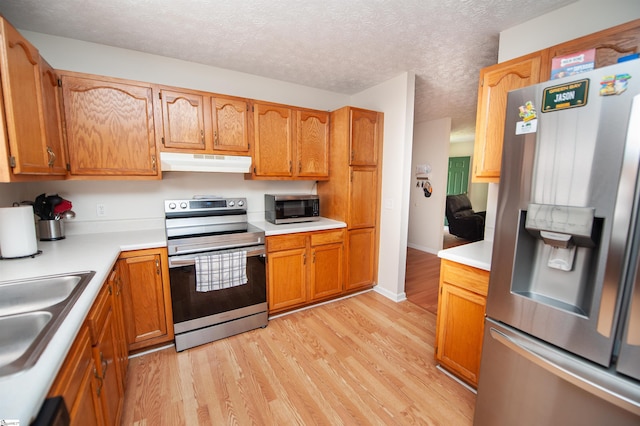 262 Bagwell Dr, Pauline, SC 29374 - kitchen with appliances with stainless steel finishes, under cabinet range hood, light wood finished floors, light countertops, and brown cabinetry