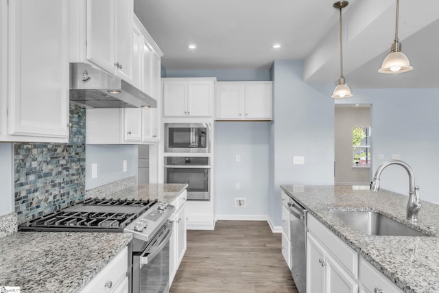 10 Wiltshire Cir, Easley, SC 29642 - kitchen featuring appliances with stainless steel finishes, under cabinet range hood, white cabinets, wood finished floors, and decorative backsplash