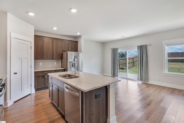 6 Shorncliffe Rd, Simpsonville, SC 29680 - kitchen with stainless steel appliances, light wood finished floors, dark brown cabinets, backsplash, and a kitchen island with sink