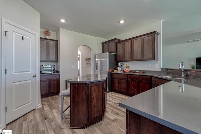 4002 Hometown Way, Boiling Springs, SC 29316 - kitchen featuring arched walkways, stainless steel fridge with ice dispenser, dark brown cabinets, and a center island