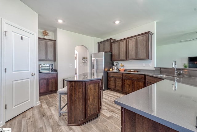 4002 Hometown Way, Boiling Springs, SC 29316 - kitchen with stainless steel refrigerator with ice dispenser, arched walkways, a center island, light wood-type flooring, and dark brown cabinets