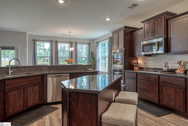 4002 Hometown Way, Boiling Springs, SC 29316 - kitchen with stainless steel appliances, light wood finished floors, a center island, dark brown cabinets, and dark countertops