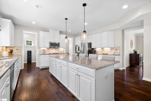 202 Princeton Dr, Duncan, SC 29334 - kitchen featuring stainless steel appliances, a kitchen island, tasteful backsplash, dark wood-type flooring, and white cabinets