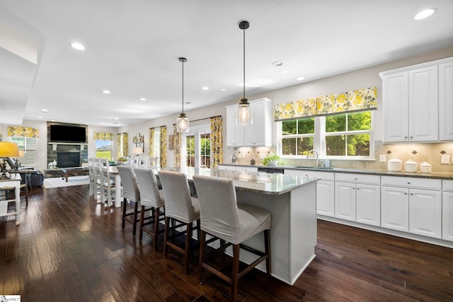 202 Princeton Dr, Duncan, SC 29334 - kitchen with backsplash, recessed lighting, light stone counters, a center island, and white cabinets