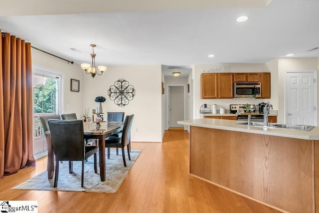 431 Lynnell Way, Moore, SC 29369 - kitchen featuring appliances with stainless steel finishes, brown cabinets, a chandelier, light countertops, and light wood-type flooring