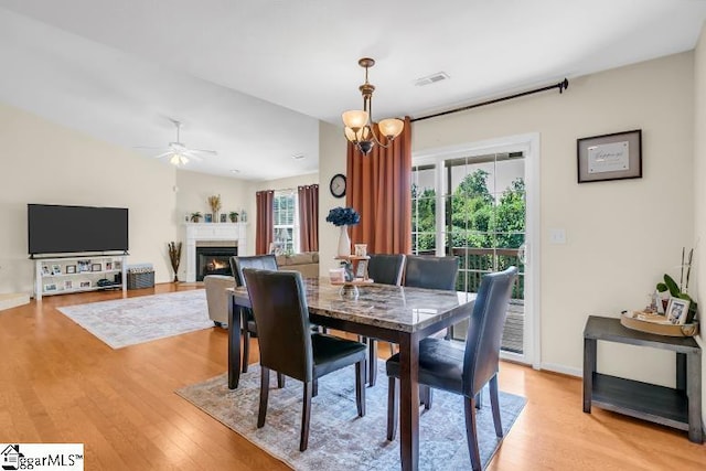 431 Lynnell Way, Moore, SC 29369 - dining space with light wood-style flooring, a lit fireplace, and a ceiling fan