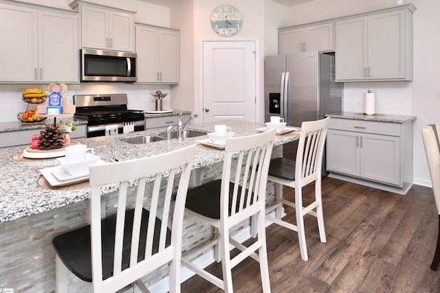 805 Colmore Trl, Lyman, SC 29365 - kitchen featuring stainless steel appliances, decorative backsplash, gray cabinets, a kitchen breakfast bar, and dark wood-type flooring