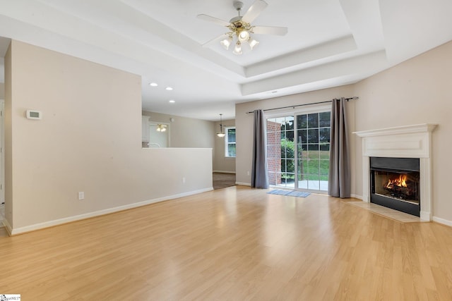 415 N Pond View Dr, Duncan, SC 29334 - unfurnished living room with light wood finished floors, a fireplace with flush hearth, a tray ceiling, a ceiling fan, and recessed lighting