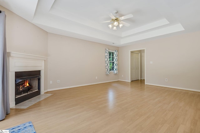 415 N Pond View Dr, Duncan, SC 29334 - unfurnished living room featuring a tray ceiling, a ceiling fan, light wood-style flooring, and a fireplace with flush hearth