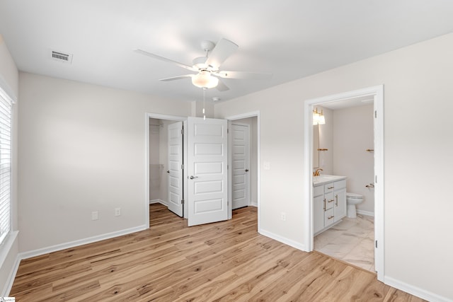 41 Leander Dr, Greer, SC 29651 - unfurnished bedroom with a spacious closet, light wood finished floors, ensuite bathroom, a closet, and a ceiling fan