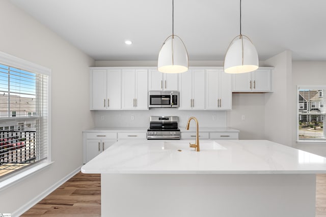 41 Leander Dr, Greer, SC 29651 - kitchen with stainless steel appliances, light wood finished floors, white cabinets, decorative light fixtures, and recessed lighting