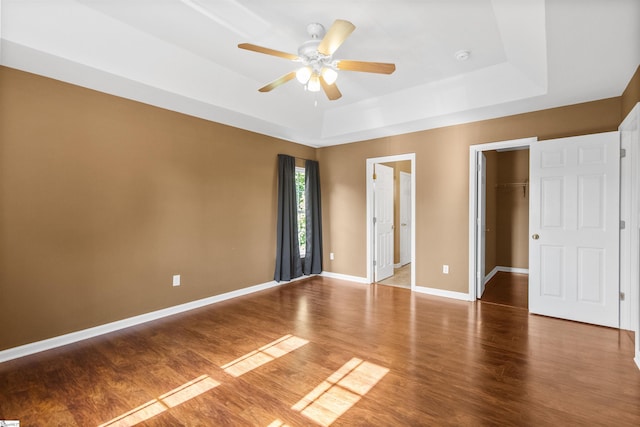 118 Moonshadow Ct, Duncan, SC 29334 - unfurnished bedroom with wood finished floors, a tray ceiling, a walk in closet, a closet, and a ceiling fan
