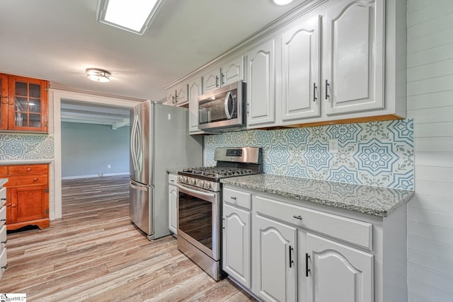 160 Bill Roberson Rd, Enoree, SC 29335 - kitchen featuring appliances with stainless steel finishes, light wood finished floors, tasteful backsplash, white cabinetry, and light stone countertops