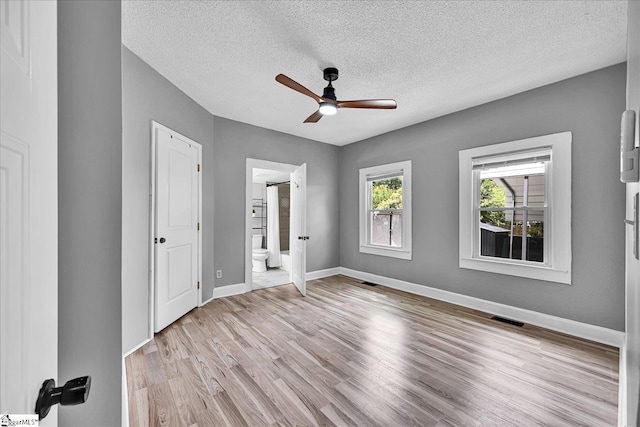 23 Stringer St, Belton, SC 29627 - unfurnished bedroom featuring light wood finished floors, a textured ceiling, ensuite bathroom, and a ceiling fan