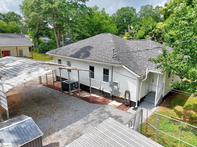 23 Stringer St, Belton, SC 29627 - back of property with roof with shingles, gravel driveway, and view of scattered trees