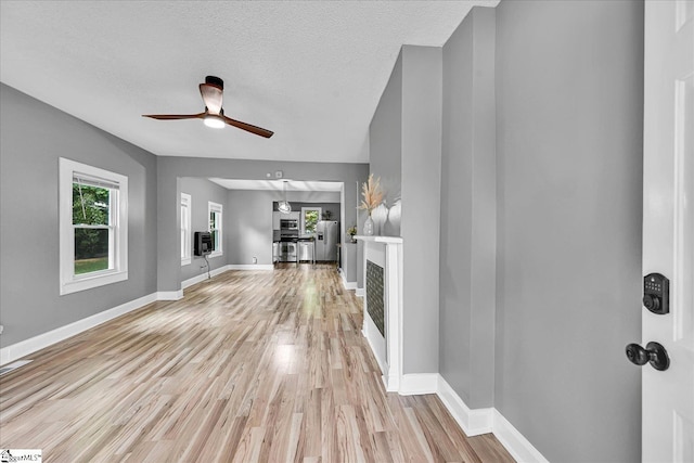 23 Stringer St, Belton, SC 29627 - unfurnished living room with light wood-style floors, ceiling fan, and a textured ceiling