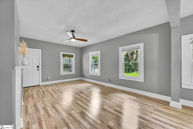 23 Stringer St, Belton, SC 29627 - unfurnished living room with plenty of natural light, a ceiling fan, a textured ceiling, and light wood-style flooring