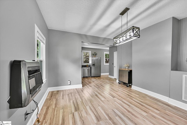 23 Stringer St, Belton, SC 29627 - unfurnished dining area featuring heating unit, wood finished floors, a textured ceiling, and a chandelier