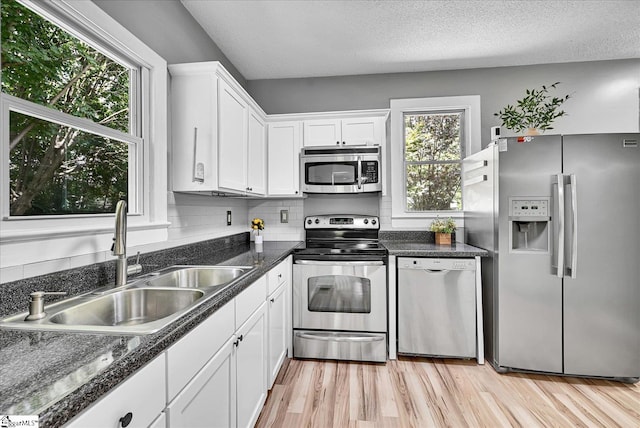 23 Stringer St, Belton, SC 29627 - kitchen featuring stainless steel appliances, white cabinets, light wood finished floors, a textured ceiling, and backsplash