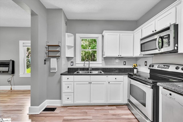 23 Stringer St, Belton, SC 29627 - kitchen with appliances with stainless steel finishes, white cabinetry, decorative backsplash, heating unit, and light wood-style floors