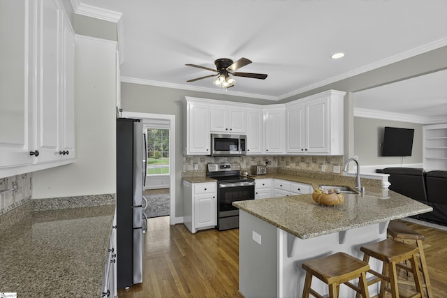 509 Wentworth Farm Cir, Boiling Springs, SC 29316 - kitchen featuring appliances with stainless steel finishes, a peninsula, a ceiling fan, white cabinetry, and a kitchen breakfast bar