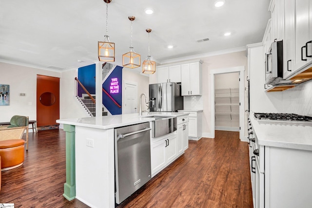 214 Terrapin Cross Way, Simpsonville, SC 29680 - kitchen with appliances with stainless steel finishes, ornamental molding, light countertops, white cabinetry, and an island with sink